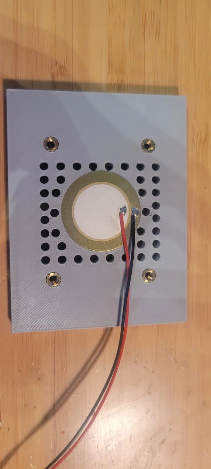 The inside face of the rear plug showing a shallow recessed pocket cut for a piezo disc, with a relief channel at one edge.