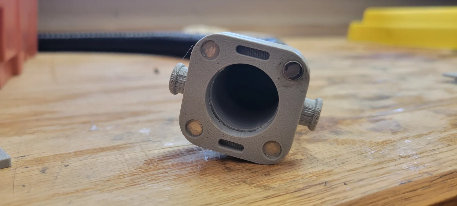 Close up of the printed quick connect body with a length of grey 1 inch corrugated hose pushed onto its socket.